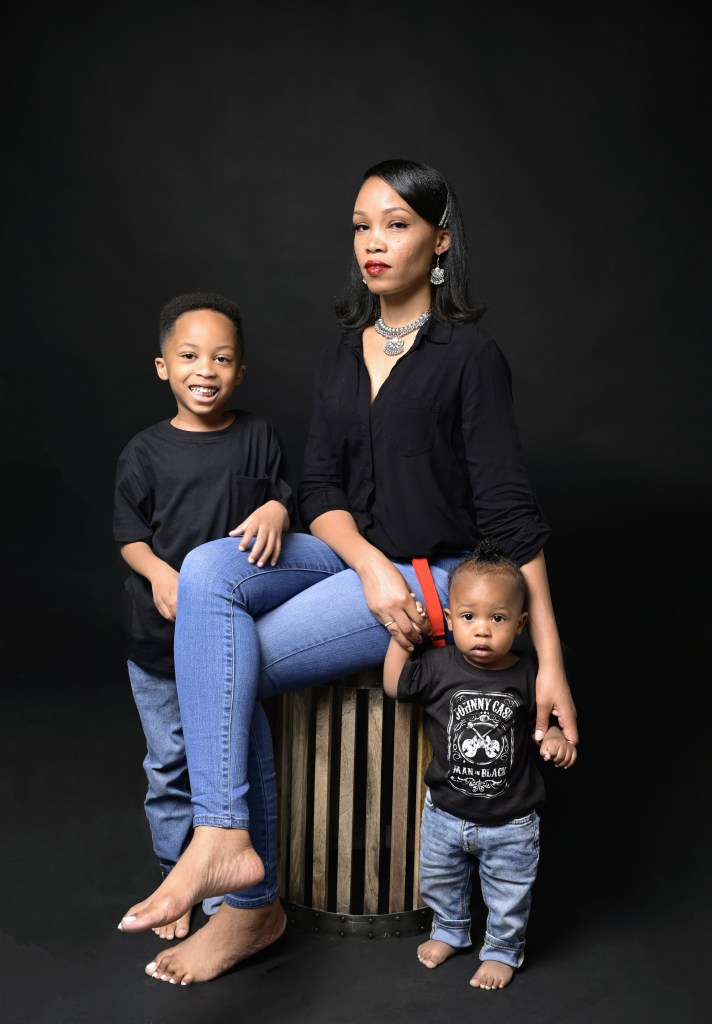 mother and two sons dressed in blue jeans and black tops